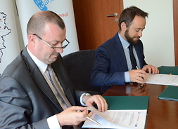 członek zarządu Wiesław Raboszuk i wiceprezydent Michał Olszewski podpisują stosowne dokumenty