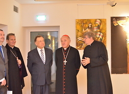 Dyrektor Muzeum Archidiecezji Warszawskiej ks. Mirosław Nowak prezentuje gościom ekspozycję.