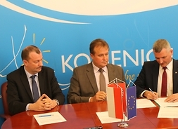 Członek zarządu województwa mazowieckiego (po prawej) podpisuje umowę