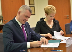 Od lewej członek zarządu Rafał Rajkowski oraz burmistrz miasta i gminy Pilawa Albina Łubian podpisują umowę