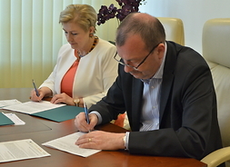 Od lewej: członek zarządu Elżbieta Lanc oraz wicemarszałek Wiesław Raboszuk podpisują umowę