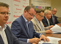 Przedstawiciele zarządu województwa mazowieckiego i beneficjent podpisują umowę