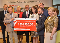 Przedstawiciele zarządu województwa mazowieckiego i m. st. Warszawy z symbolicznym czekiem