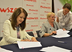Wicemarszałek Janina Ewa Orzełowska oraz przedstawicielka Gminnego Ośrodka Kultury w Jadowie podpisują umowę