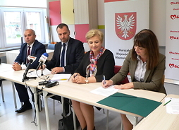 Wicemarszałek Janina Ewa Orzełowska (pierwsza po prawej) podpisuje umowę