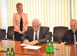 Piotr Galiński zastępca burmistrza Grodziska Mazowieckiego po lewej podpisuje umowę