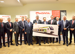 Marszałek Adam Struzik oraz przedstawiciele Kolei Mazowieckich i firmy Stadler prezentują wizualizację nowego pociągu