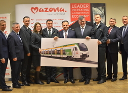 Marszałek Adam Struzik oraz przedstawiciele Kolei Mazowieckich i firmy Stadler prezentują wizualizację nowego pociągu
