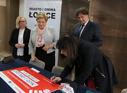 Wicemarszałek Janina  Ewa Orzełowska podpisuje symboliczny czek
