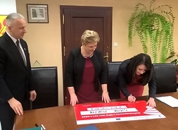 Pamiątkowy czek podpisuje wicemarszałek Janina Ewa Orzełowska