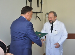 Marszałek Adam Struzik gratulujelekarzowi pracującemu w szpitalu