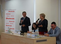 Członek zarządu województwa Elżbieta Lanc po prawej i Marian Krupiński radny województwa po lewe stronie rozmawiają o programie z beneficjentami