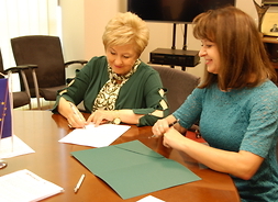 Członek zarządu Elżbieta Lanc podpisuje umowy