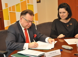 marszałek Adam Struzik podpisuje umowę, obok siedzi Monika Tchórznicka zastępca dyrektora Mazowieckiej Jednostki Wdrażania Programów Unijnych
