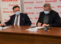 Tomasz Lewandowski podpisuje umowę