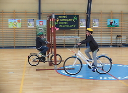 dwójka dzieci pokonujących na rowerach tor